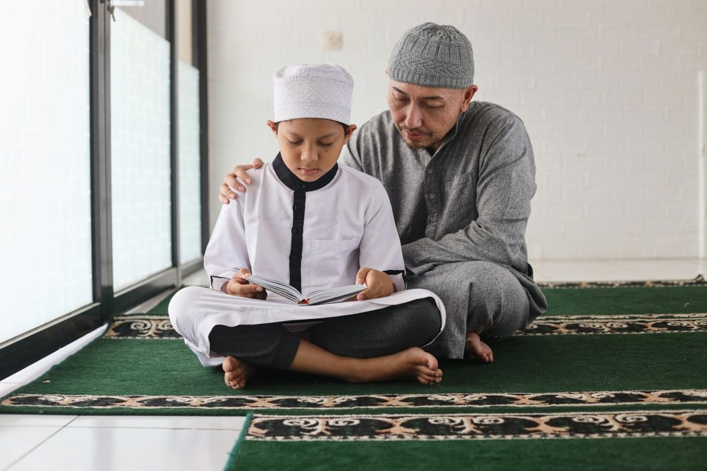 Father teaching son reading Al Qur'an