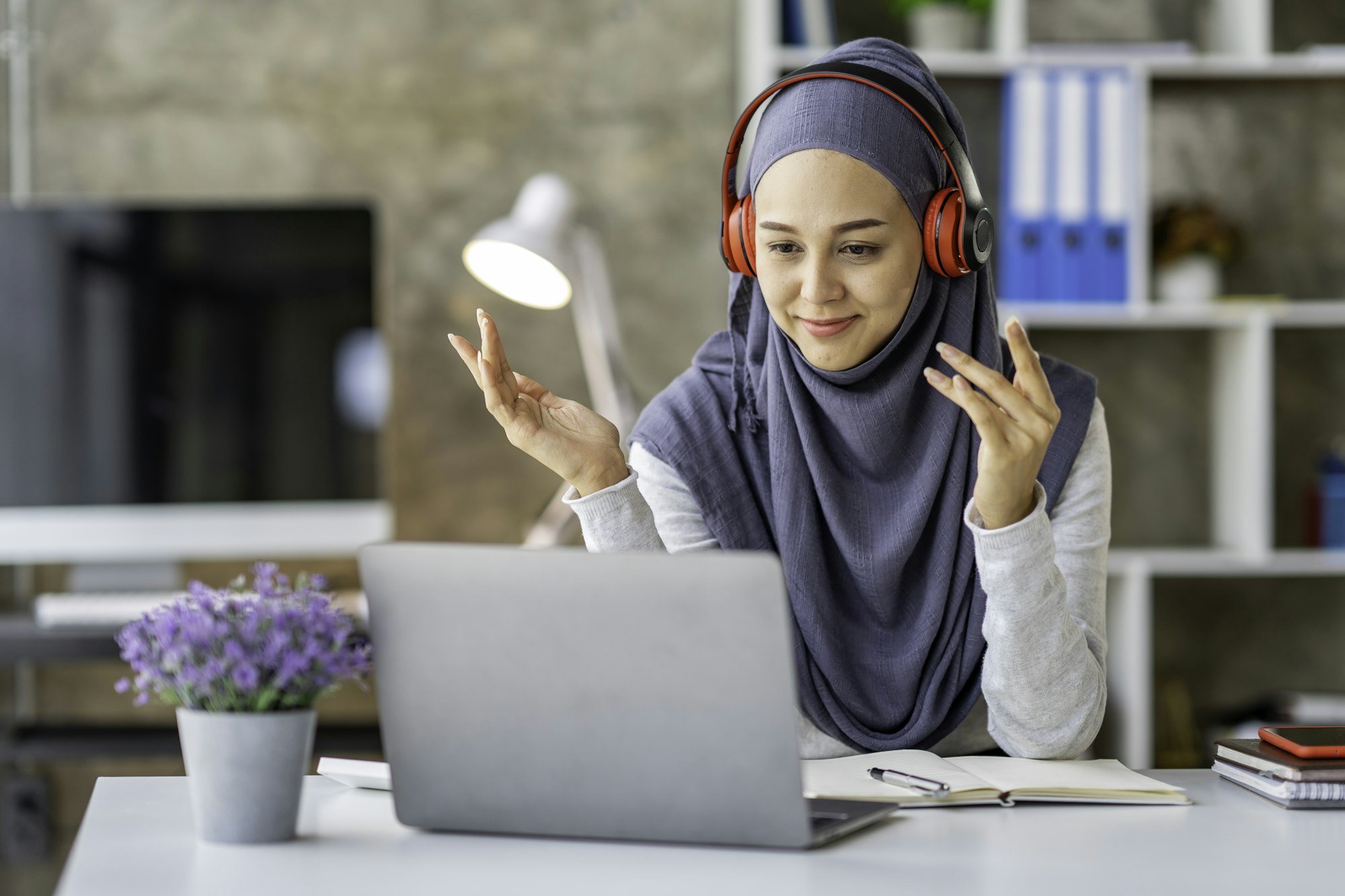 Muslim businesswoman wearing a hijab looks at camera working Online Tutoring. Young Muslim woman tea